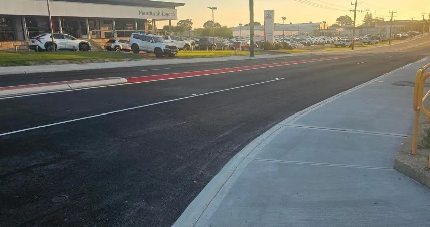 Completed road with car vehicle yard in background